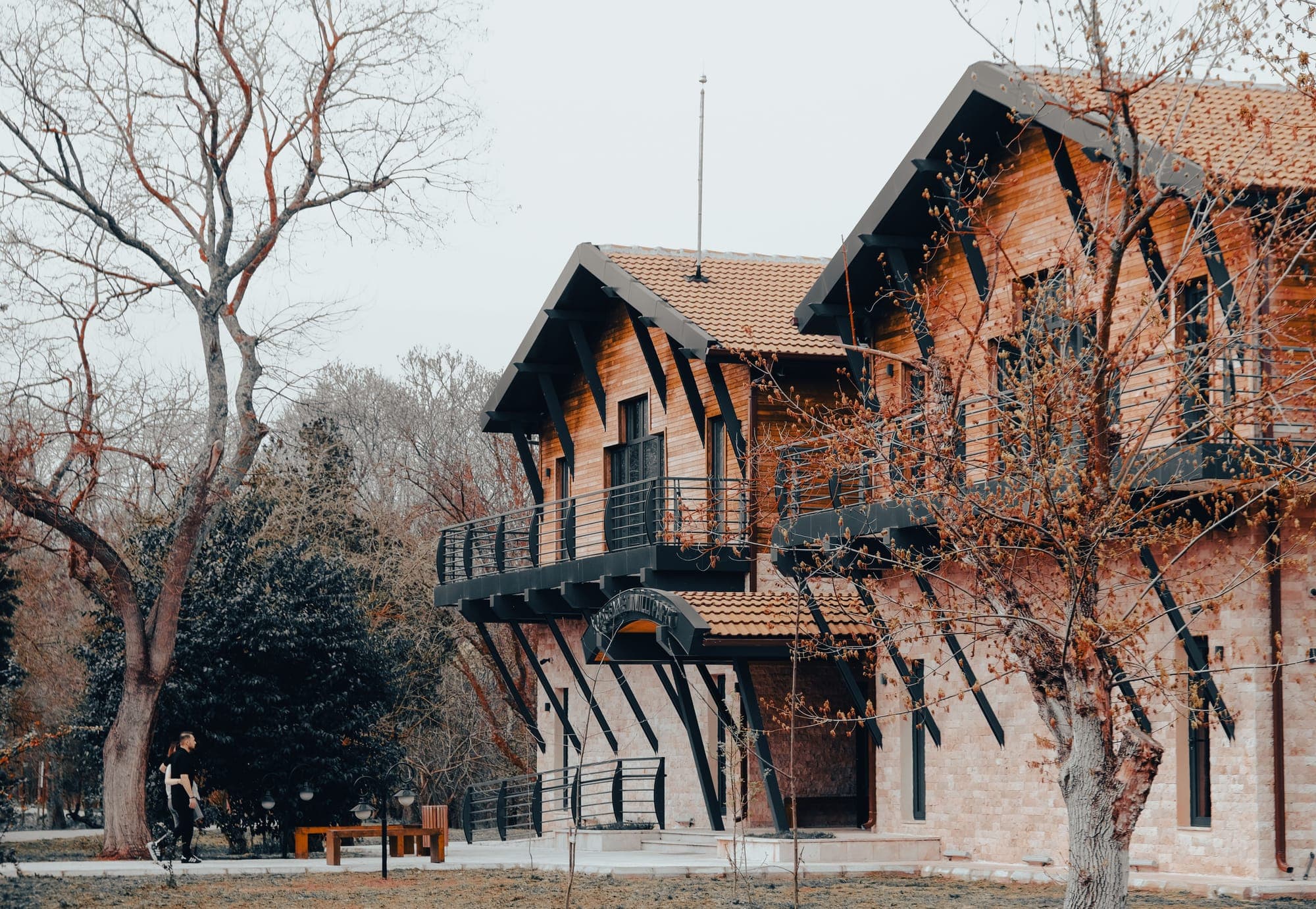 Hostería de piedra y madera con balcones, rodeada de árboles